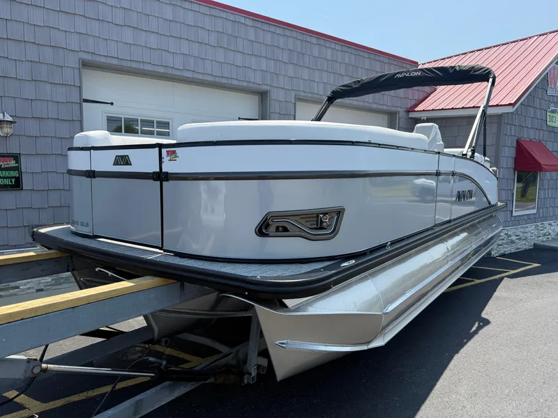 Slide: The Image of 2025 Avalon 2385 Catalina Quad Lounger Tri Toon boat on trailer, outside building. - 3