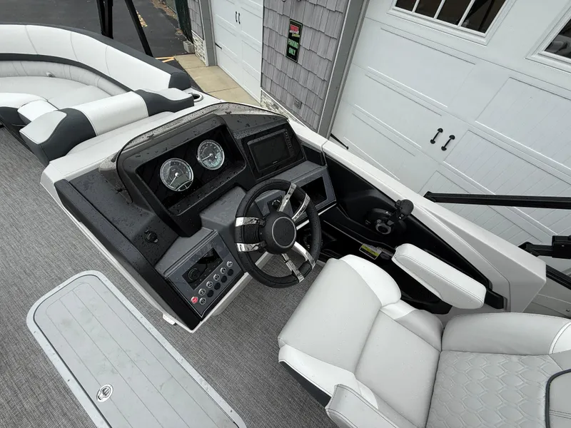 Slide: The Image of 2025 Avalon 2385 Catalina Quad Lounger boat interior with modern dashboard and seating. - 18