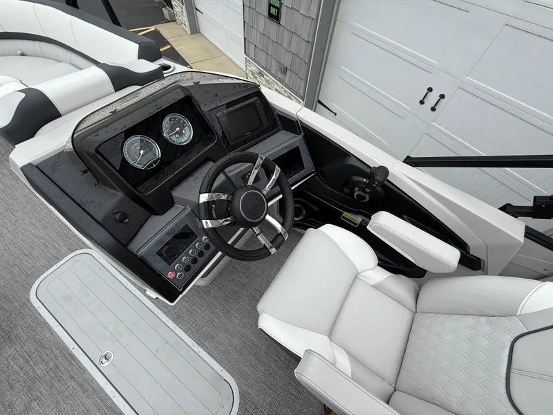 Slide: The Image of 2025 Avalon 2385 Catalina Quad Lounger boat dashboard with steering wheel and gauges. - 20