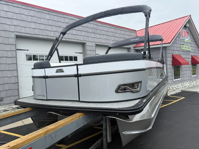 Slide: The Image of 2025 Avalon 2385 Catalina Quad Lounger Tri Toon boat on trailer, parked outside building. - 4