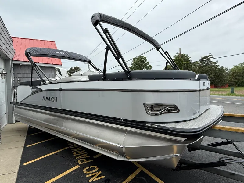 Slide: The Image of 2025 Avalon 2385 Catalina Quad Lounger Tri Toon boat on trailer, parked outdoors. - 8