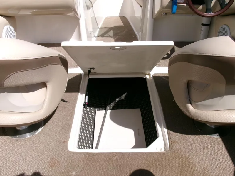 Slide: The Image of 2007 Chaparral 210 SSi boat interior with open storage compartment between seats. - 14