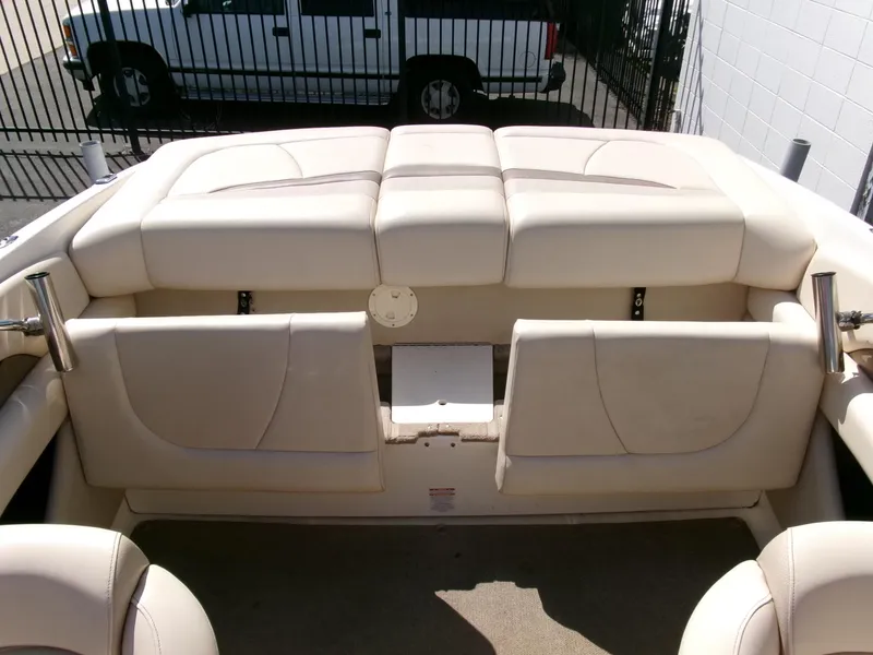 Slide: The Image of 2007 Chaparral 210 SSi boat interior with beige seating and storage compartments. - 21