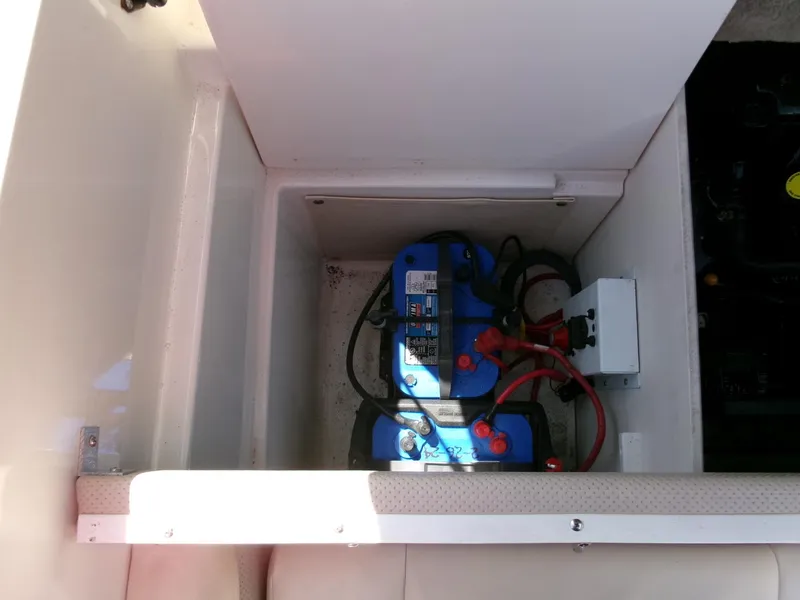 Slide: The Image of Battery compartment of 2007 Chaparral 210 SSi boat, featuring blue battery and wiring. - 24