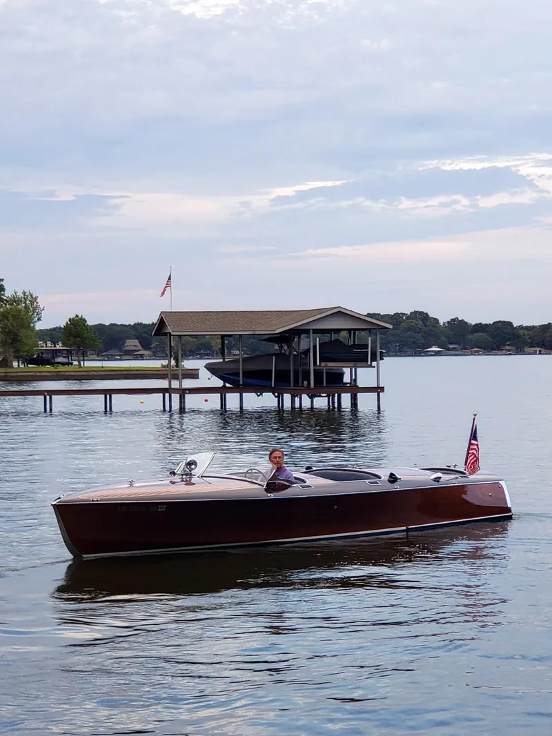 Slide: The Image of 2001 Hugh Saint Shearliner 27 boat cruising on a serene lake near a dock. - 5