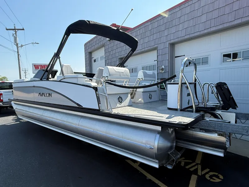 Slide: The Image of 2025 Avalon Catalina Quad Lounger Shift Windshield pontoon boat parked outside a garage. - 5