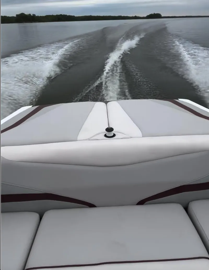 Slide: The Image of 2018 Axis T 22 boat cruising on a lake, leaving a wake behind. - 11