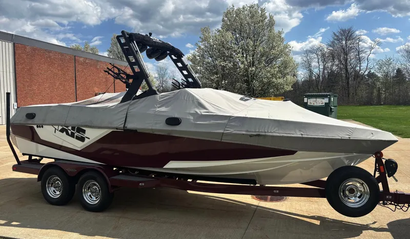 Slide: The Image of 2018 Axis T 22 boat with cover on trailer, parked outdoors. - 4