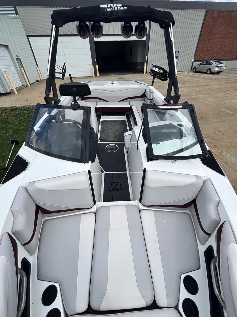 Slide: The Image of 2018 Axis T 22 boat with open seating and sleek design, parked outdoors. - 8