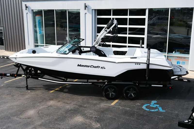 Slide: The Image of 2025 MasterCraft NXT24 boat on trailer, parked outside dealership. - 3
