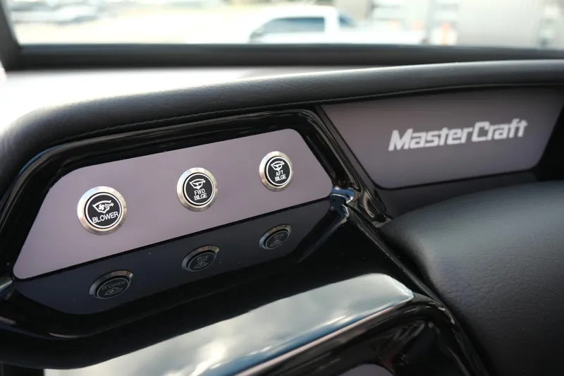 Slide: The Image of Dashboard controls of 2025 MasterCraft NXT24 boat with blower and horn buttons. - 32
