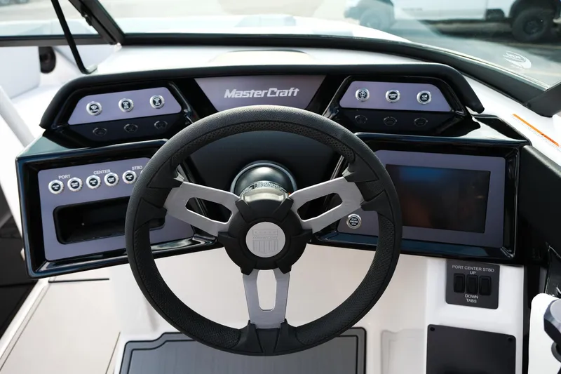 Slide: The Image of 2025 MasterCraft NXT24 boat dashboard with steering wheel and control panel. - 35