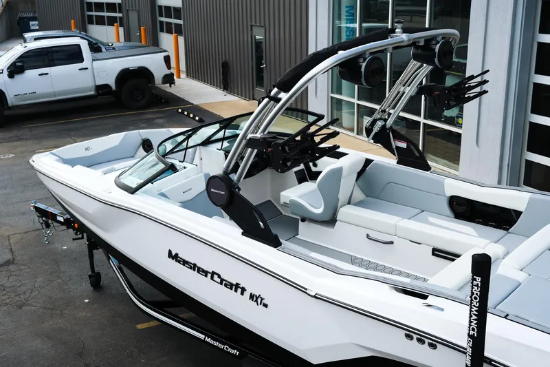 Slide: The Image of 2025 MasterCraft NXT24 boat with sleek design, parked near a modern building. - 5