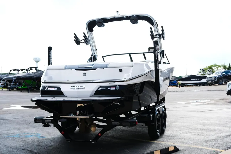 Slide: The Image of 2025 MasterCraft NXT24 boat on trailer, rear view in a parking lot. - 9