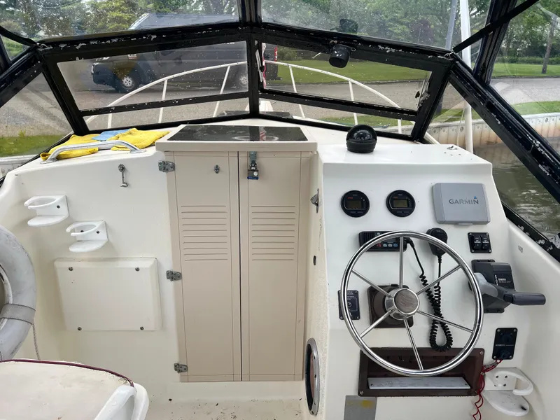 Slide: The Image of 1989 Mako 250 Cuddy Cabin boat interior with steering wheel and control panel. - 1