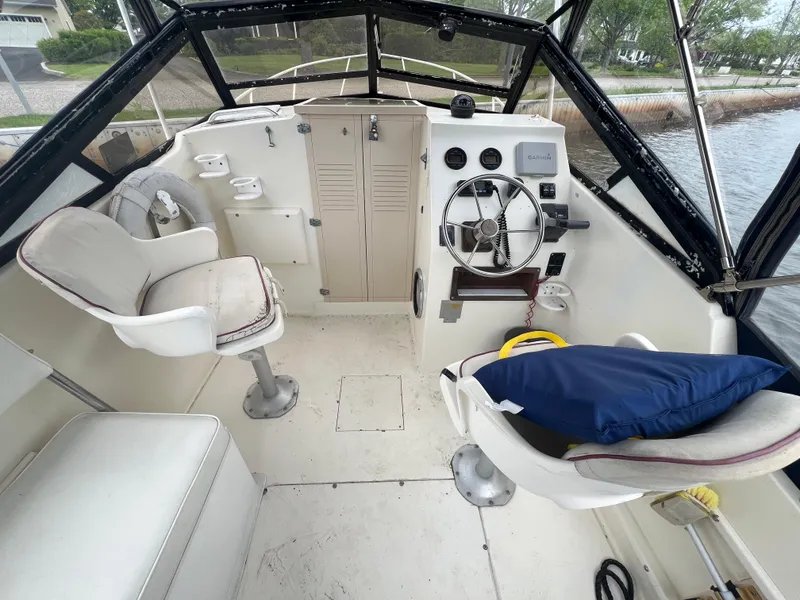 Slide: The Image of 1989 Mako 250 Cuddy Cabin boat interior with steering wheel and seating. - 13