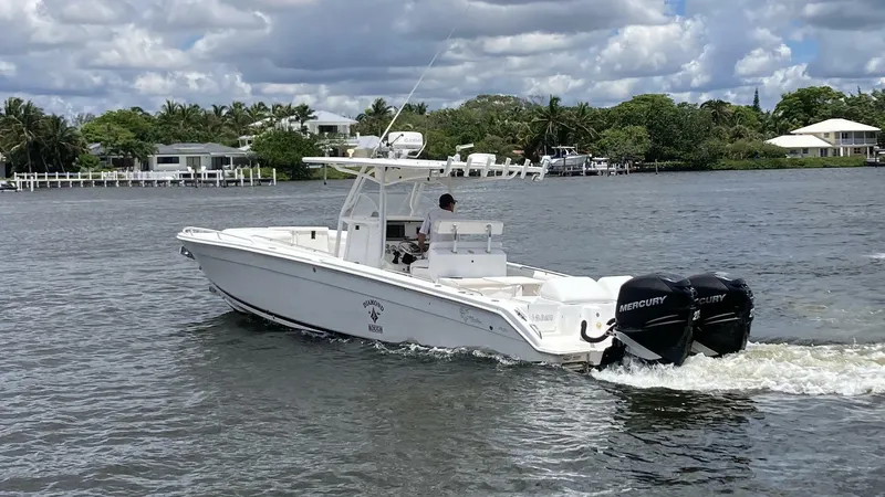Slide: The Image of 2007 Marlago 35 boat cruising on a scenic waterway with lush greenery. - 4