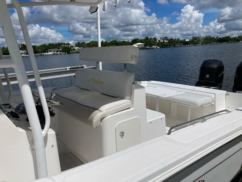 Slide: The Image of 2007 Marlago 35 boat interior with seating, helm, and water view under a cloudy sky. - 7