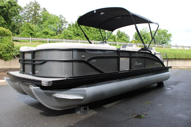 Slide: The Image of 2025 Barletta Cabrio 22M pontoon boat with canopy, parked on pavement. - 6