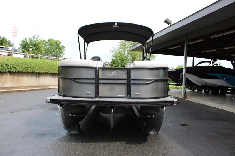 Slide: The Image of 2025 Barletta Cabrio 22M pontoon boat with canopy, parked on wet pavement. - 7