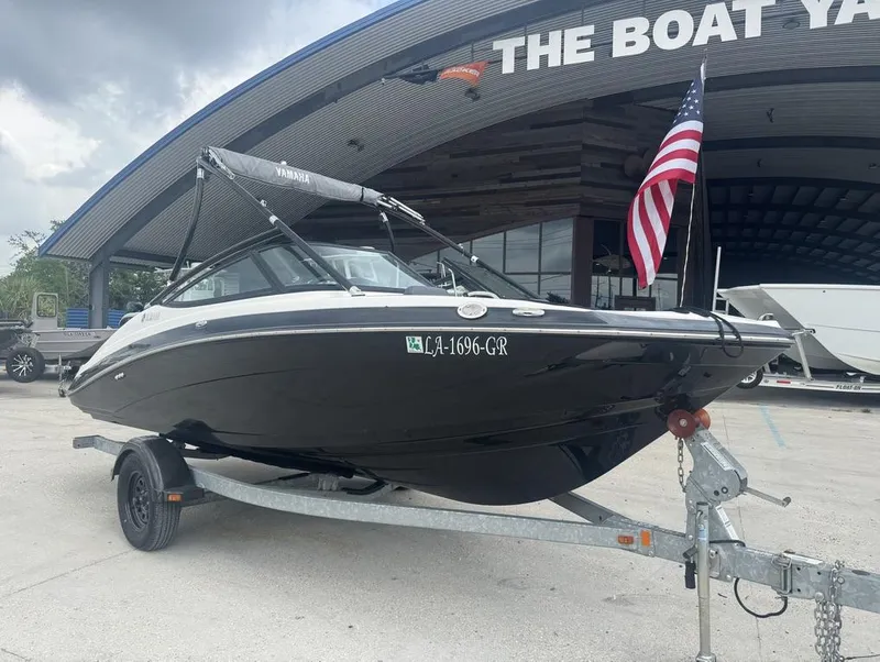 Slide: The Image of 2015 Yamaha AR190 boat on trailer at dealership, American flag displayed. - 10
