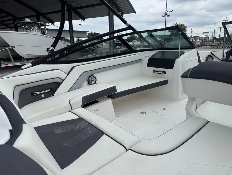 Slide: The Image of 2015 Yamaha AR190 boat interior with white and black seating, docked under a canopy. - 7