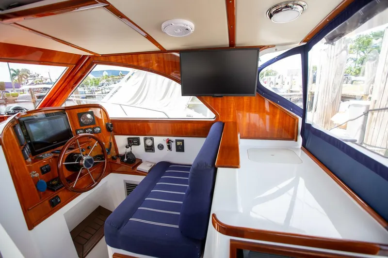 Slide: The Image of Interior of 2003 San Juan SJ 38 boat with wooden dashboard and blue seating. - 14