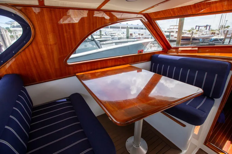 Slide: The Image of Luxurious 2003 San Juan SJ 38 yacht interior with polished wood table and blue cushioned seating. - 16