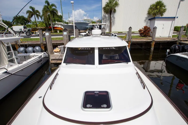 Slide: The Image of 2003 San Juan SJ 38 yacht docked at marina with palm trees in background. - 19