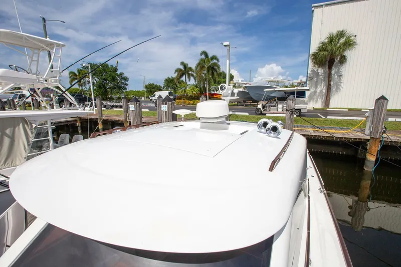 Slide: The Image of 2003 San Juan SJ 38 boat docked, featuring sleek white deck and clear blue sky. - 20