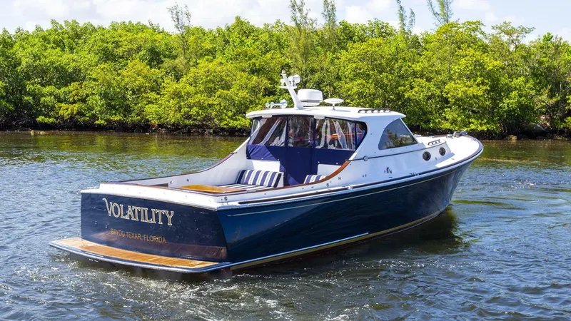 Slide: The Image of 2003 San Juan SJ 38 boat cruising on water near lush greenery. - 21