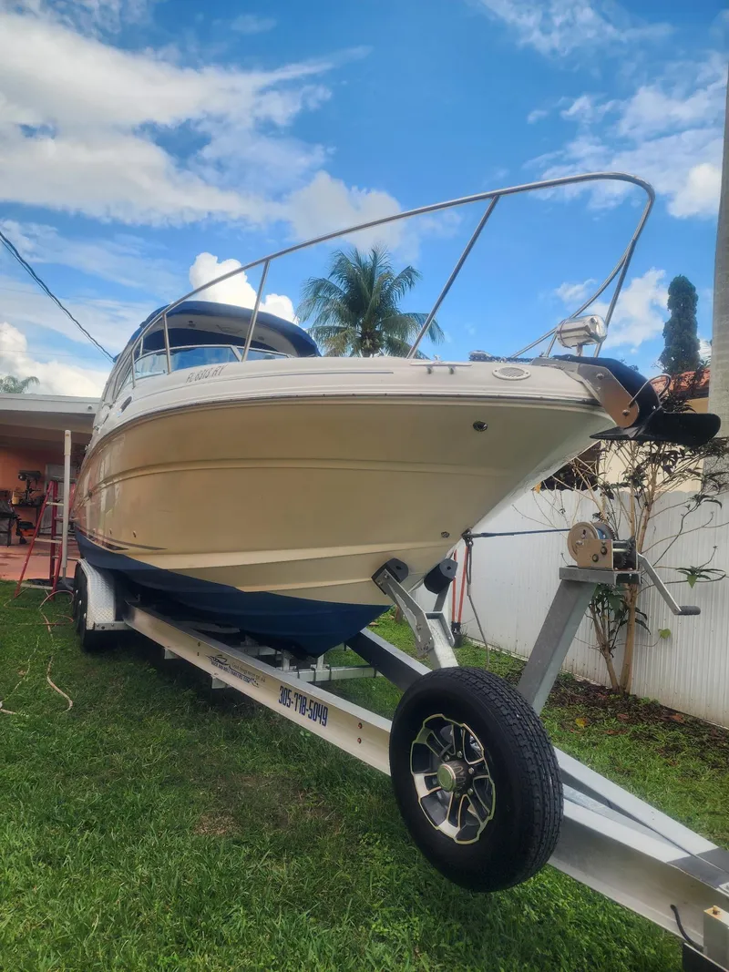 The Image of 2007 Sea Ray 280 Sundancer boat on trailer, parked on grass under a blue sky. - 0