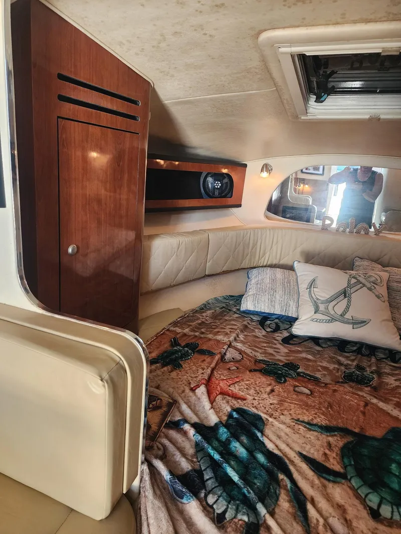 Slide: The Image of Interior cabin of 2007 Sea Ray 280 Sundancer with cozy bedding and wooden cabinetry. - 10
