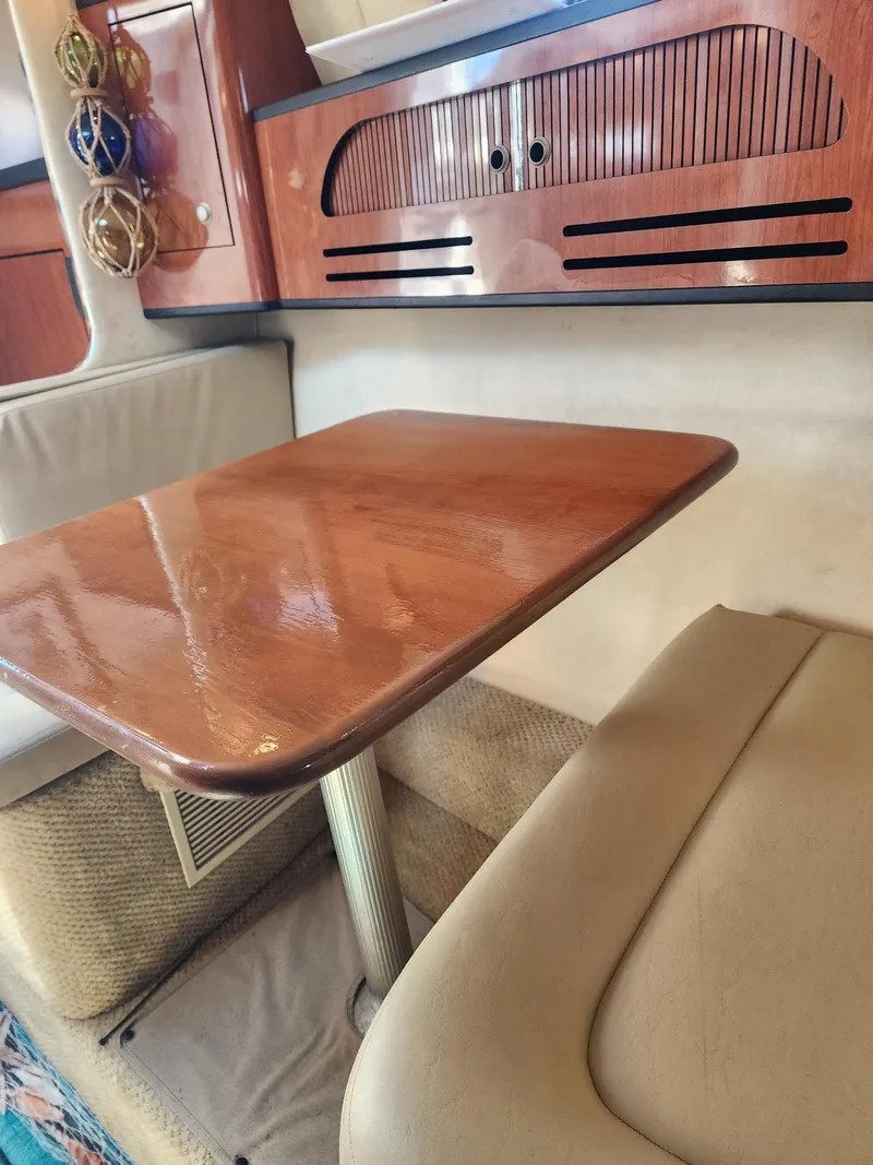 Slide: The Image of Interior of 2007 Sea Ray 280 Sundancer with wooden table and cushioned seating. - 13