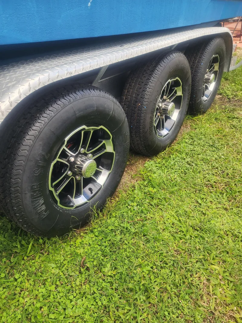 Slide: The Image of Trailer wheels of a 2007 Sea Ray 280 Sundancer on grass. - 2
