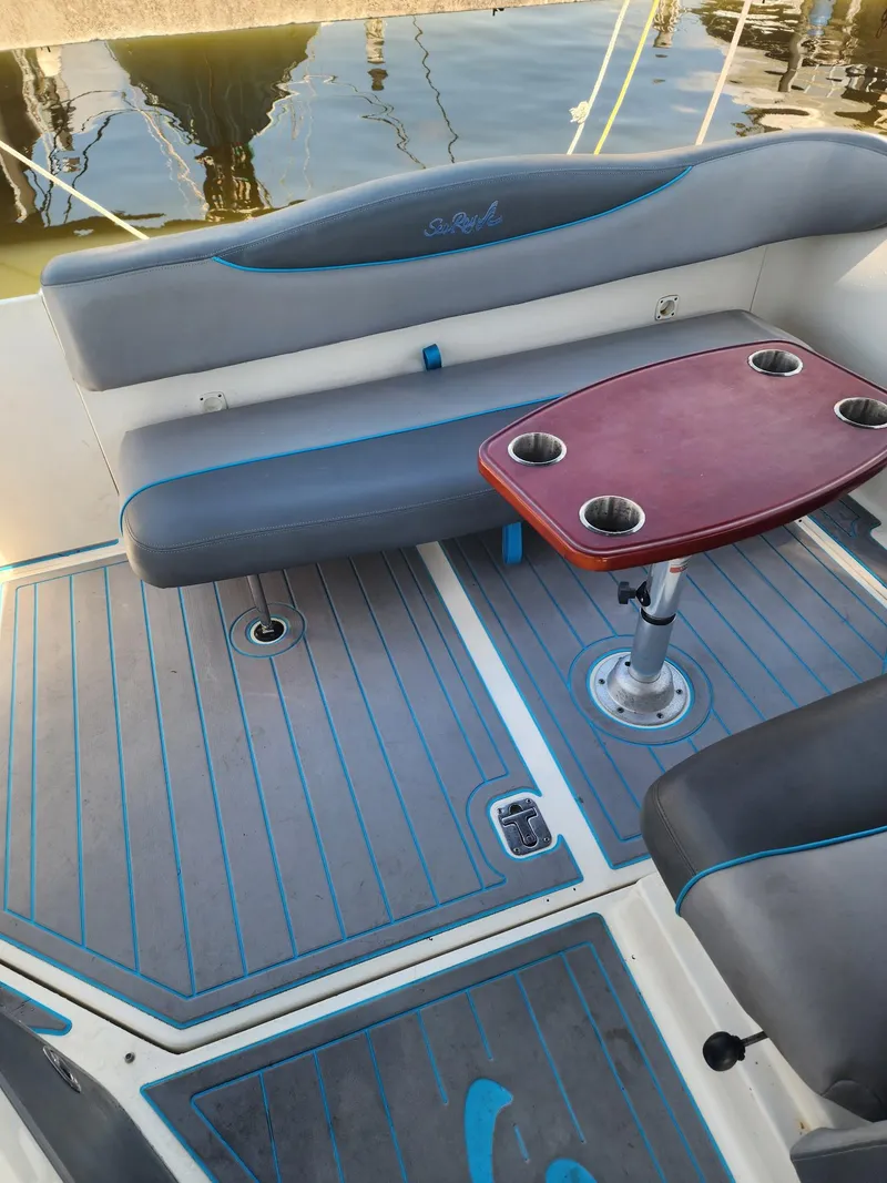 Slide: The Image of 2007 Sea Ray 280 Sundancer boat interior with seating and table, docked by the water. - 8