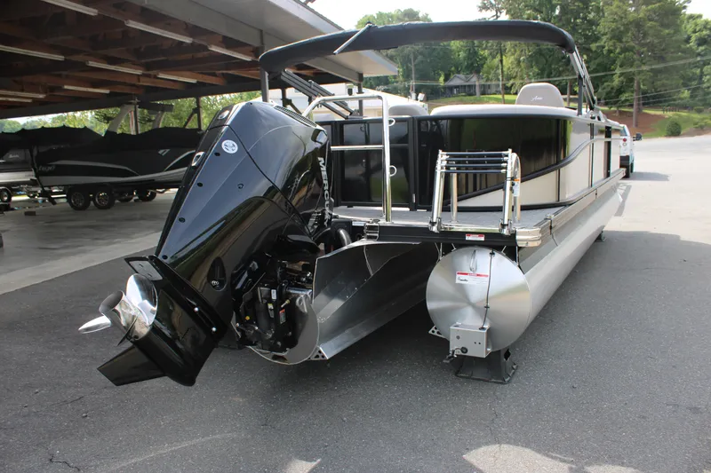 Slide: The Image of 2025 Barletta Aria 24QC pontoon boat with powerful outboard motor, parked outdoors. - 10