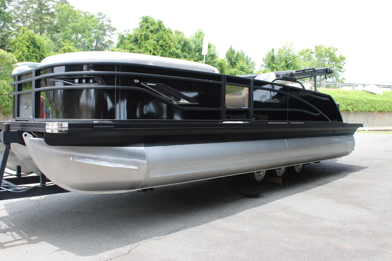 Slide: The Image of 2025 Barletta Corsa 23UC pontoon boat with sleek black design, parked outdoors. - 12