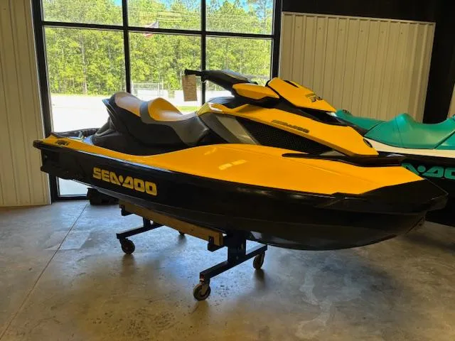 Slide: The Image of 2009 Sea-Doo RXT iS 255 jet ski in showroom, yellow and black design. - 1