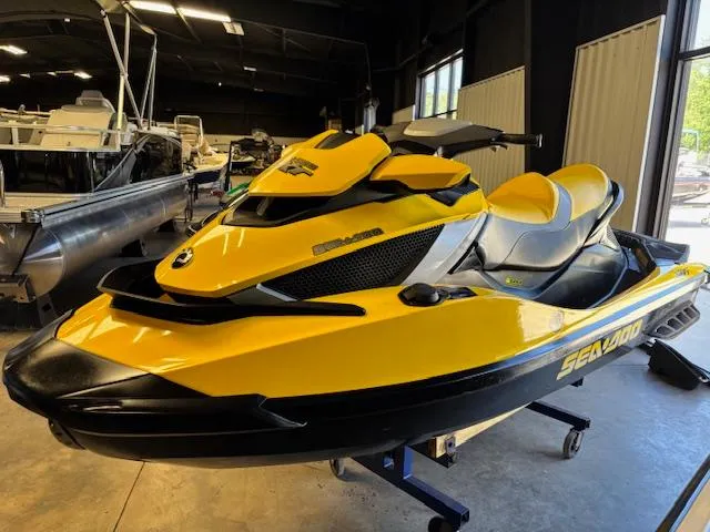 Slide: The Image of 2009 Sea-Doo RXT iS 255 jet ski in a showroom, yellow and black design. - 3