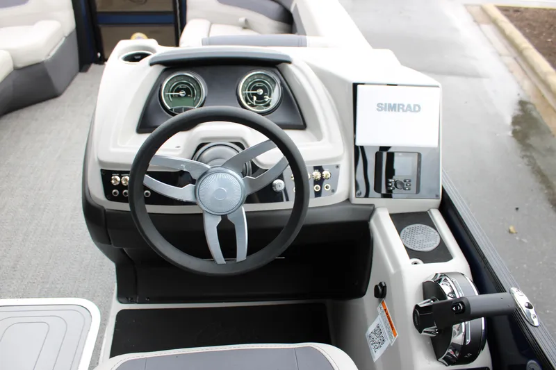 Slide: The Image of 2025 Barletta Cabrio 22QC boat dashboard with steering wheel and Simrad navigation system. - 10