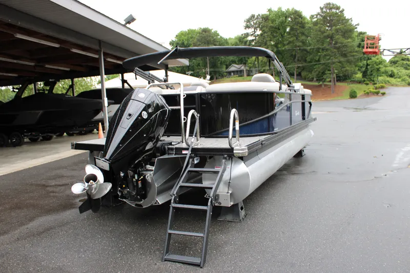 Slide: The Image of 2025 Barletta Cabrio 22QC pontoon boat with outboard motor, parked on wet pavement. - 15