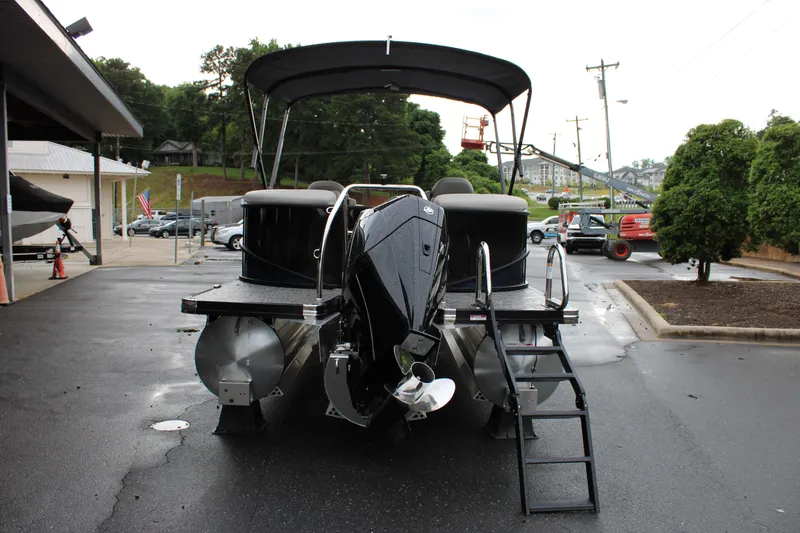 Slide: The Image of 2025 Barletta Cabrio 22QC pontoon boat with canopy, parked on wet pavement. - 4