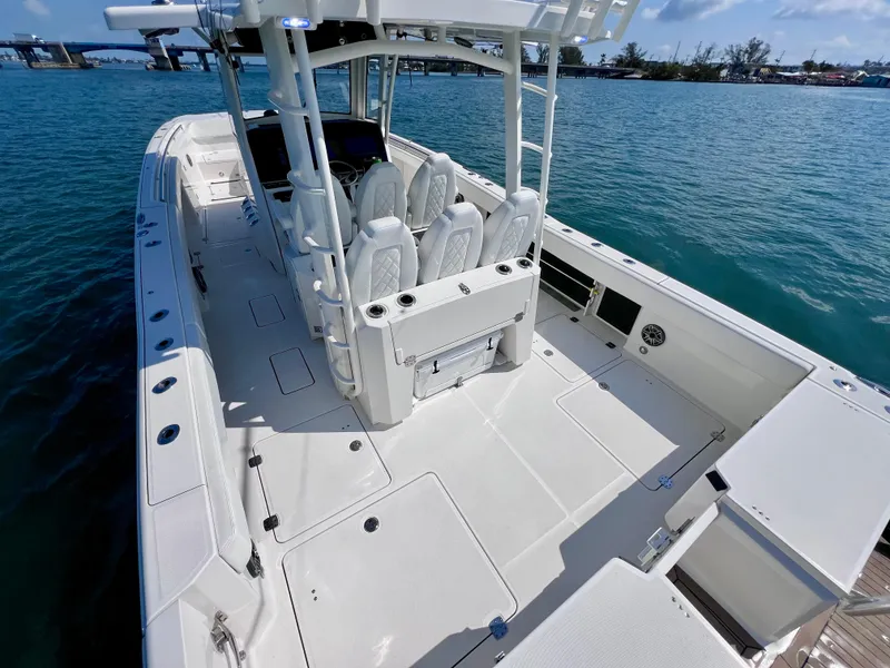 Slide: The Image of 2022 World Cat 400 CC-X boat with spacious deck and seating, docked on calm water. - 13