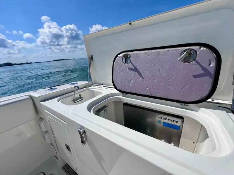 Slide: The Image of 2022 World Cat 400 CC-X boat interior with sink and storage, ocean view. - 16