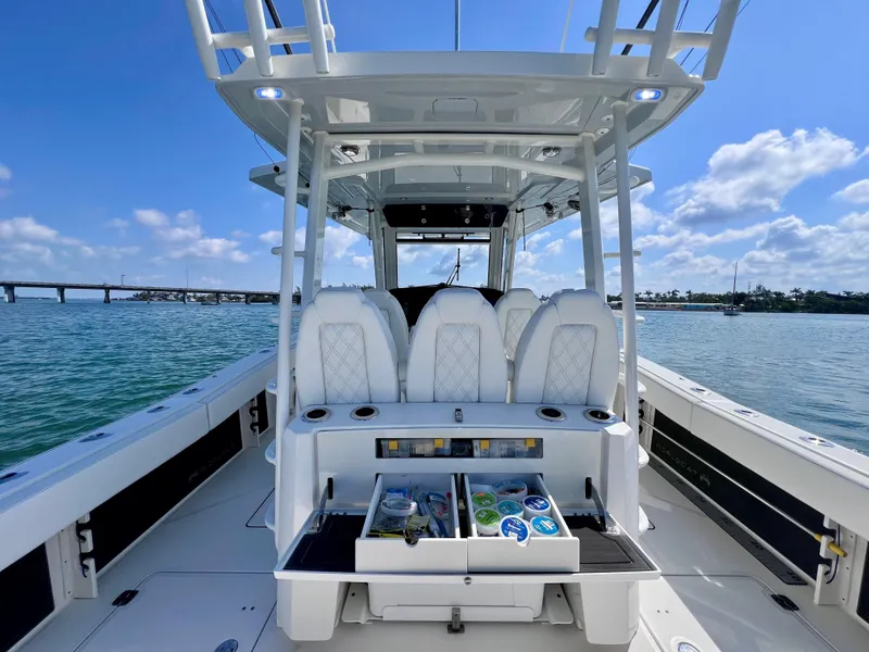 Slide: The Image of 2022 World Cat 400 CC-X boat interior with seating and storage, on a sunny day. - 22