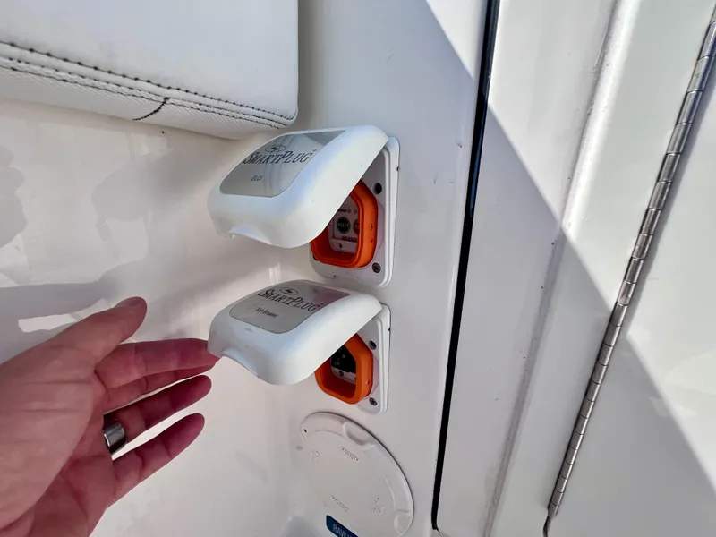 Slide: The Image of Hand interacting with power outlets on a 2022 World Cat 400 CC-X boat. - 24