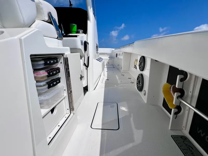 Slide: The Image of 2022 World Cat 400 CC-X boat interior with storage and speakers, under a clear blue sky. - 32