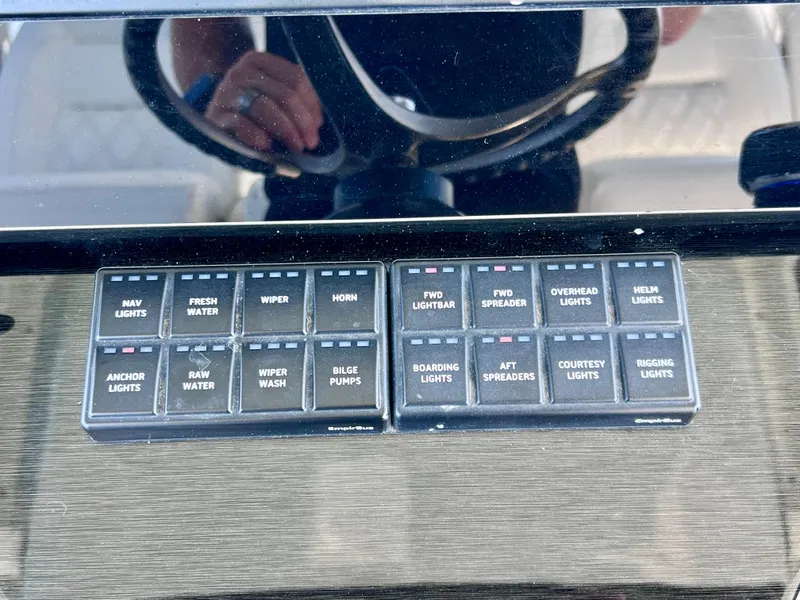 Slide: The Image of Control panel of 2022 World Cat 400 CC-X boat with various light and water switches. - 50