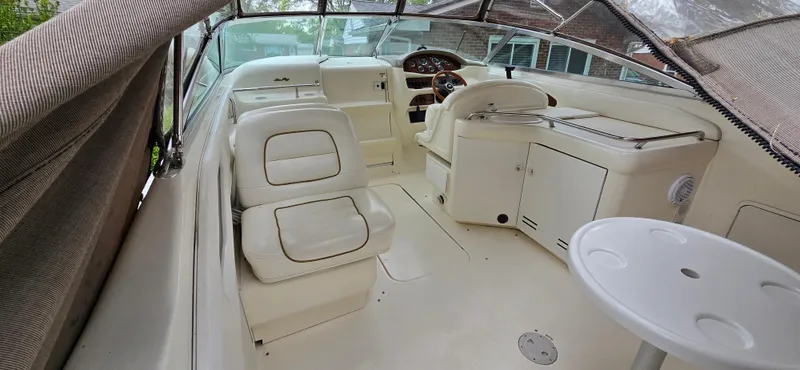Slide: The Image of 1999 Sea Ray 280 SS boat interior with white seating and helm area. - 10